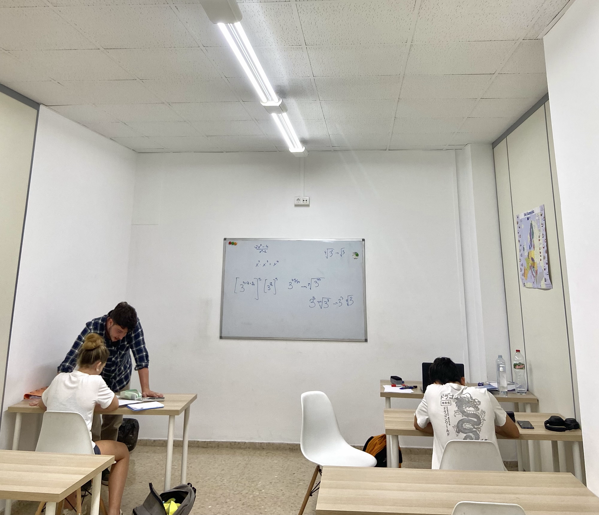 Alumnes de primària resolent operacions matemàtiques en un full i geometria.